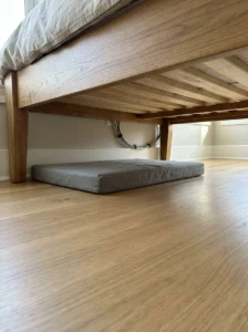 Clean and safe under-bed sleeping area for a dog