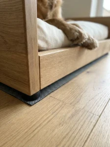 Non-slip rubber feet beneath a wooden dog bed on an oak floor