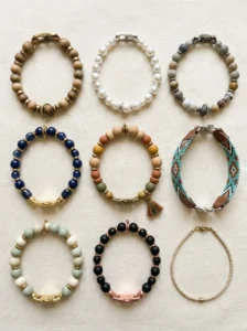 Nine handmade beaded dog collar designs in pearl, wood, navy, sage, and gold tones.