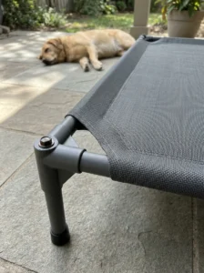 Inspecting an outdoor dog bed for damaged mesh and unsafe frame edges