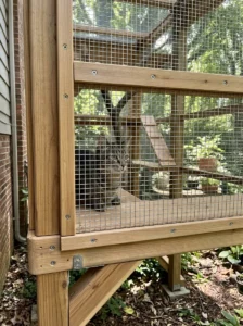 Secure DIY catio with sturdy mesh and anchored wooden frame